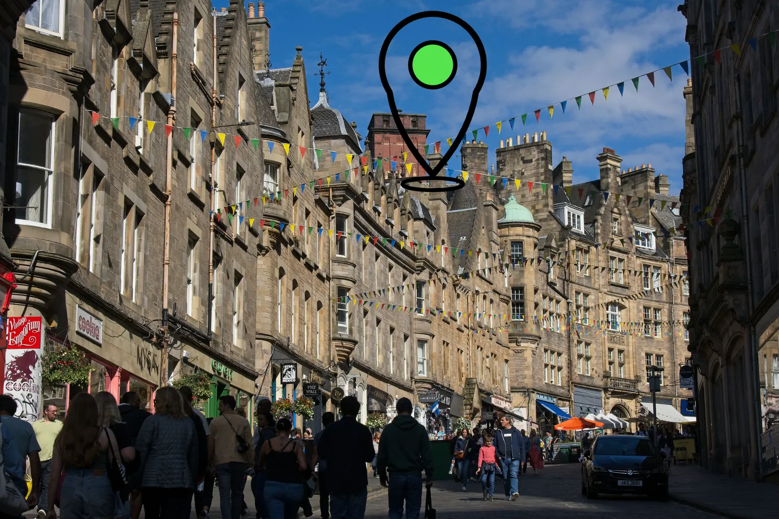 Cockburn Street in Edinburgh's Old Town, with a drawn location pin above the rooftops